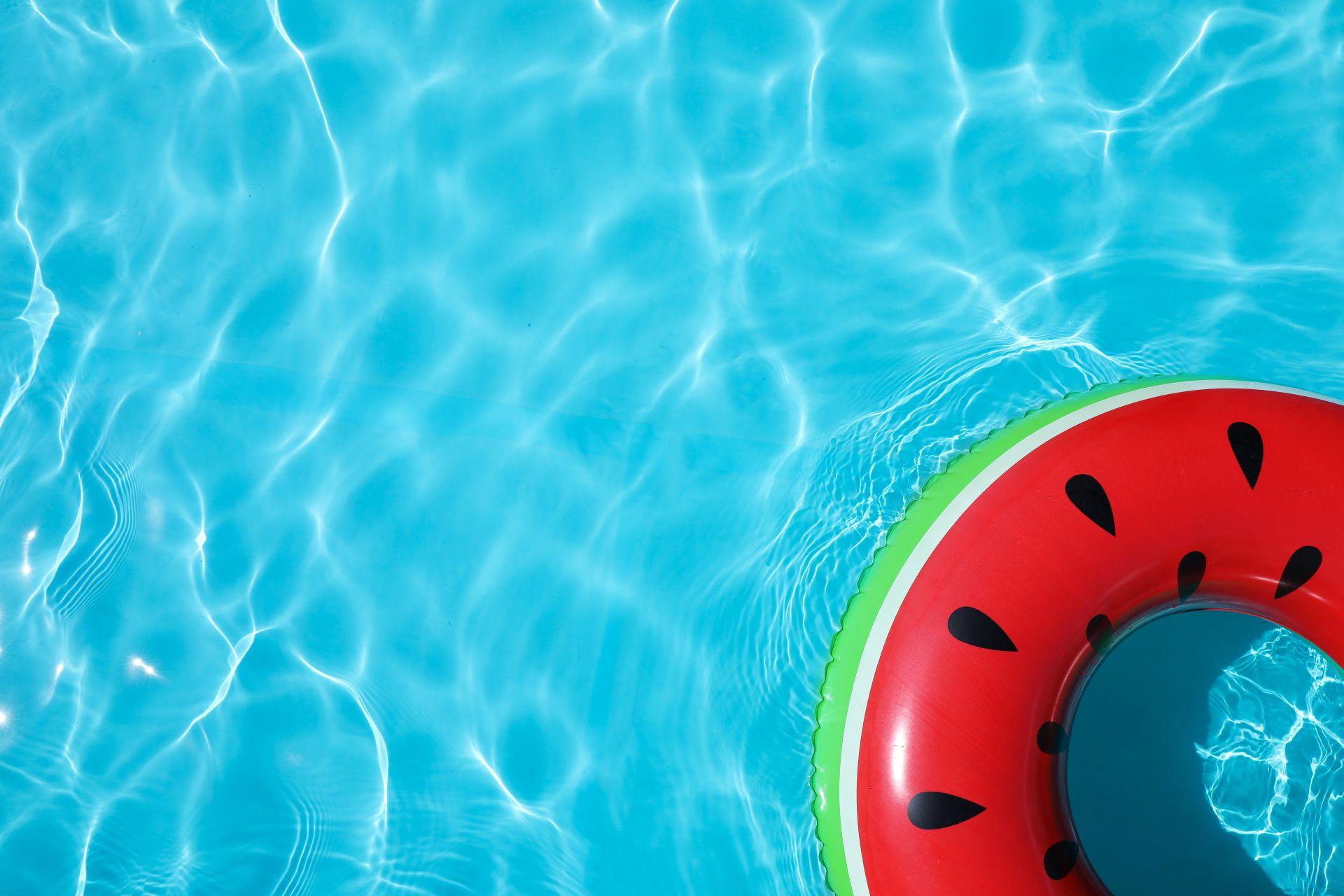 Blick von oben auf klares blaues Poolwasser mit aufblasbarem Wassermelonenring im Stahlwand-Pool Oval
